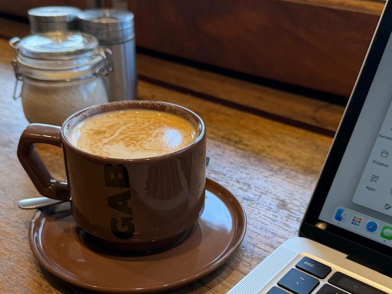 Café e computador sobre a mesa, planejando a semana